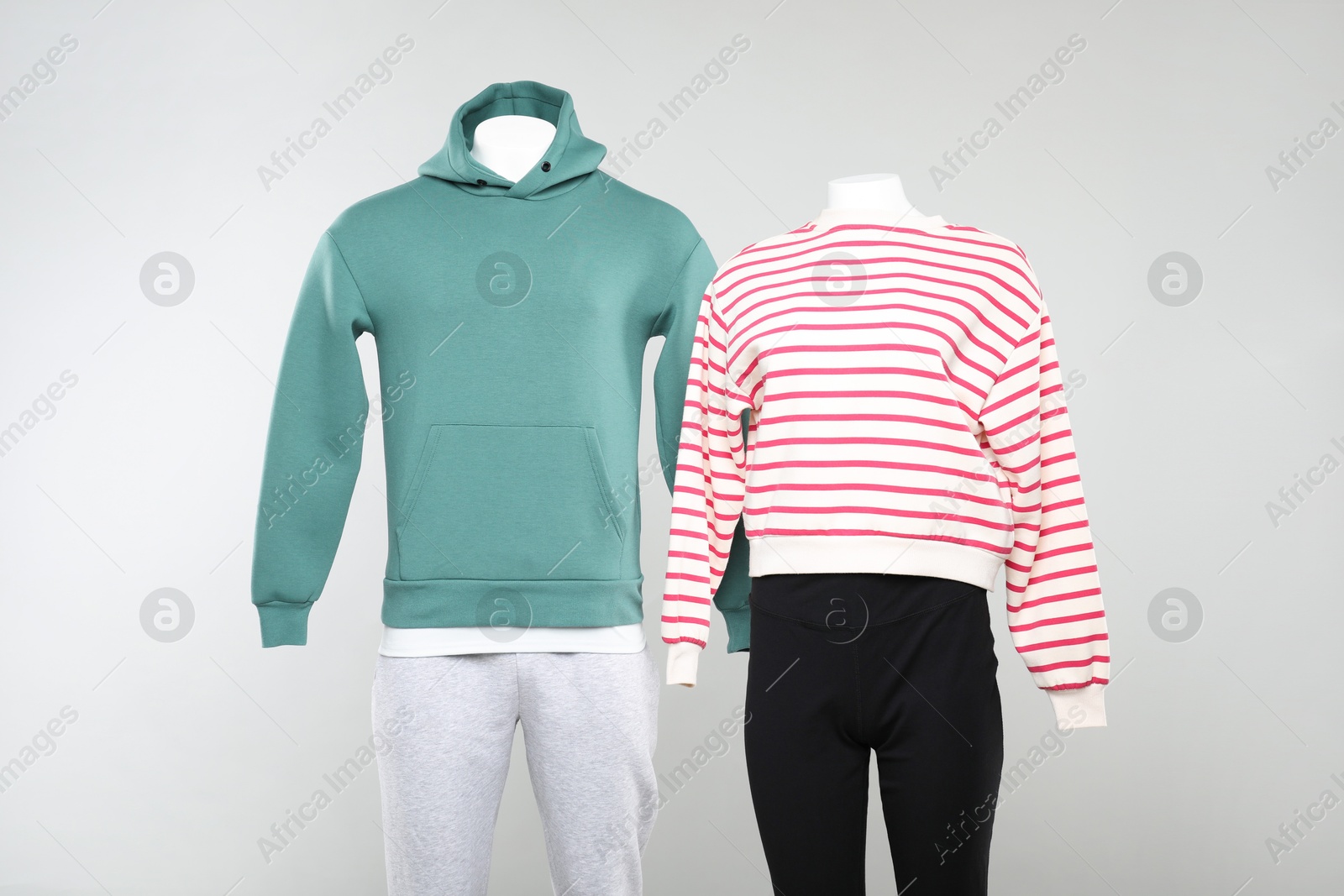 Photo of Female and male mannequins with stylish outfits on light background