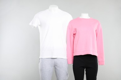 Photo of Female and male mannequins with stylish outfits on light background