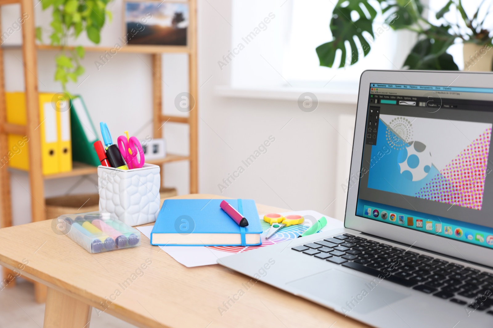 Photo of Designer's workplace with laptop and stationery on wooden table indoors