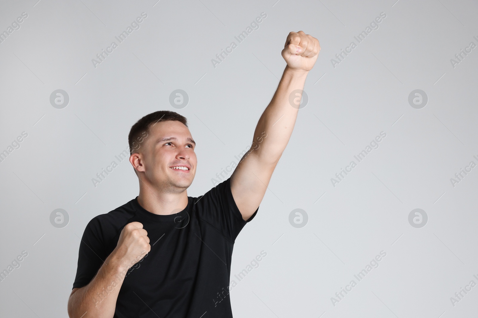 Photo of Portrait of happy winner on light grey background, space for text