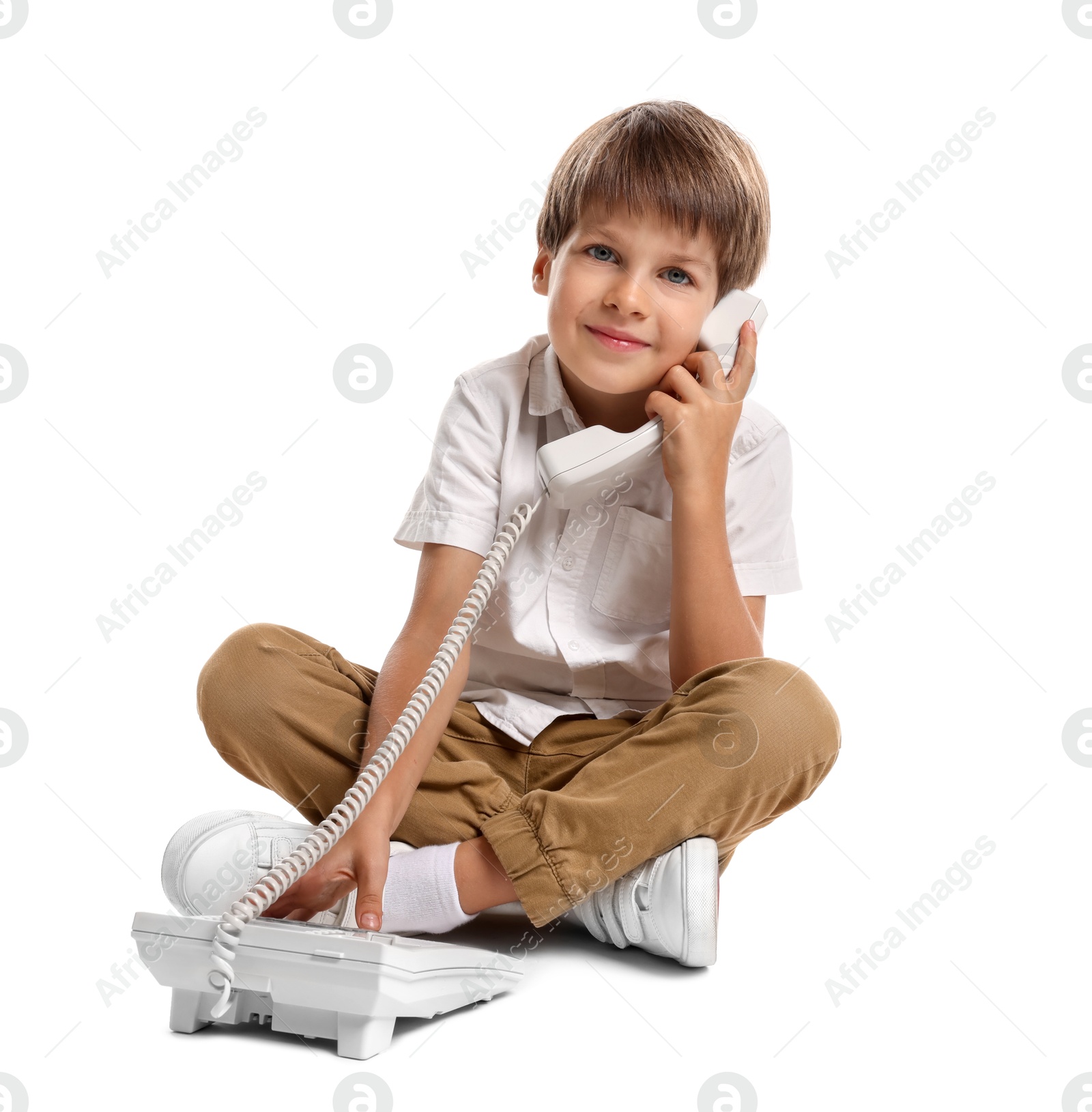 Photo of Cute little boy with telephone on white background