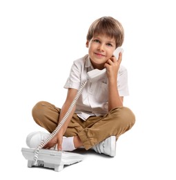 Photo of Cute little boy with telephone on white background