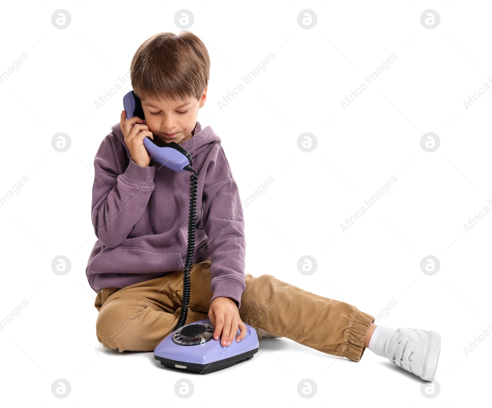 Photo of Cute little boy with old telephone on white background