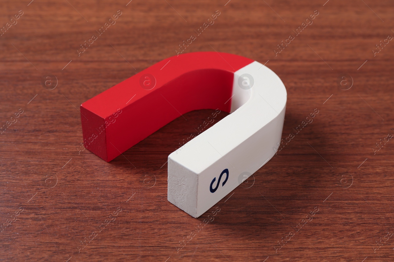 Photo of One color horseshoe magnet on wooden table