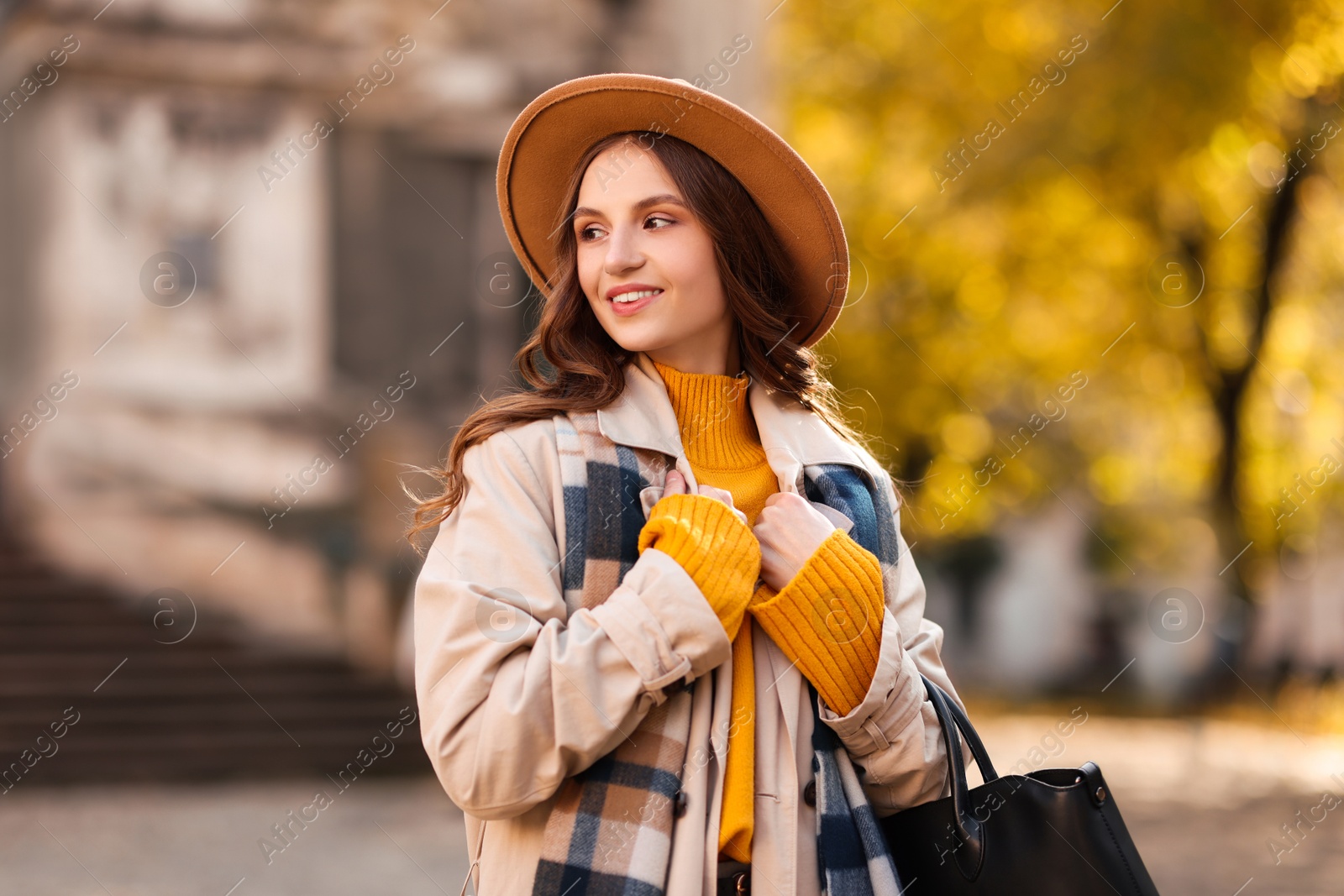 Photo of Charming young woman in stylish outfit on city street. Autumn season