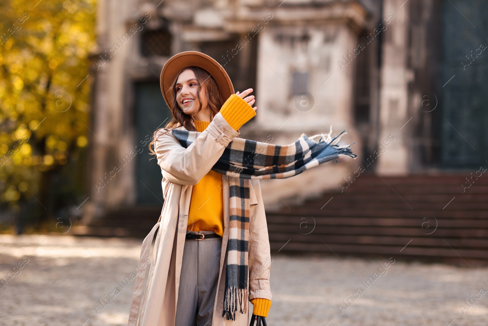 Photo of Charming young woman in stylish outfit on city street. Autumn season