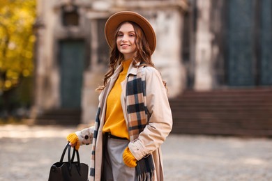 Photo of Charming young woman in stylish outfit on city street. Autumn season