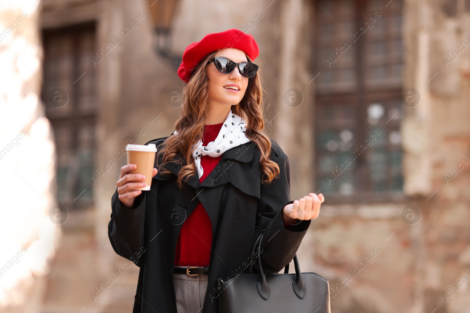 Photo of Charming young woman with cup of coffee on city street. Autumn season