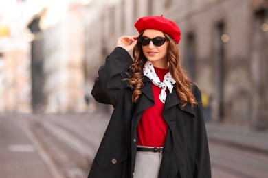 Photo of Charming young woman in stylish outfit on city street. Autumn season