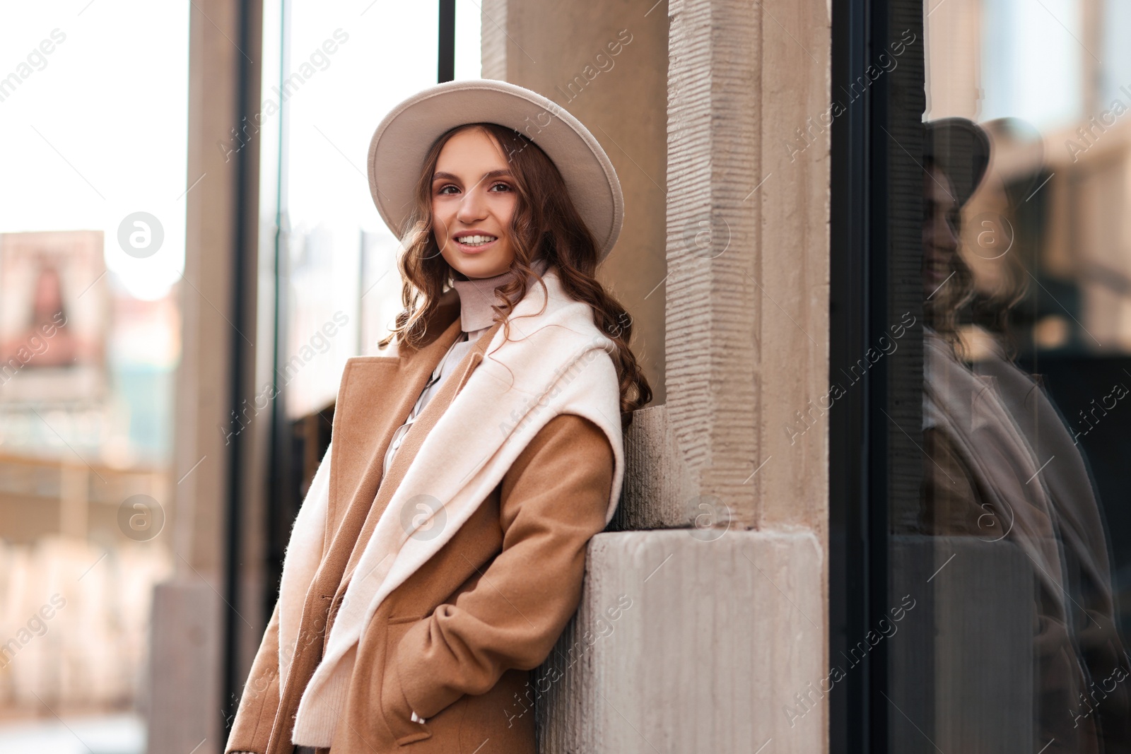 Photo of Charming young woman near shop on city street, space for text