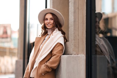 Photo of Charming young woman near shop on city street, space for text