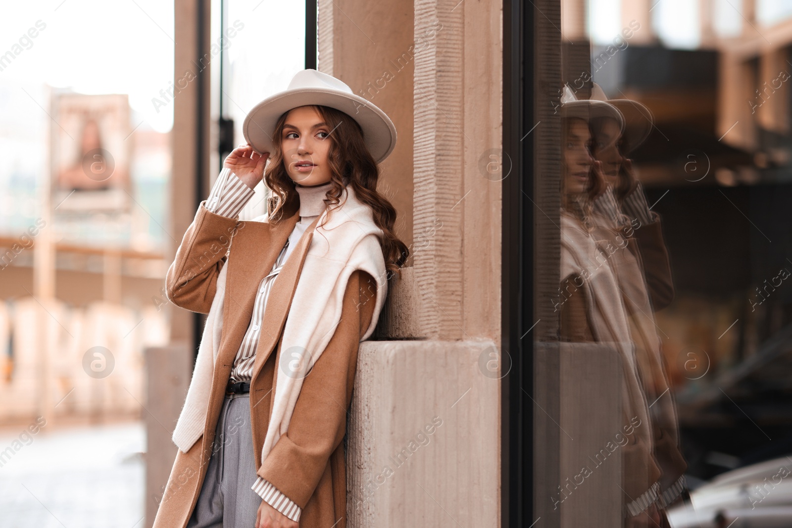 Photo of Charming young woman near shop on city street, space for text