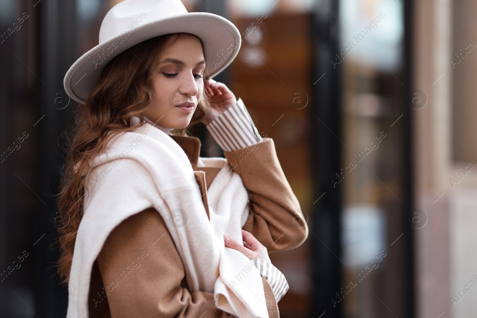 Photo of Charming young woman near shop on city street, space for text