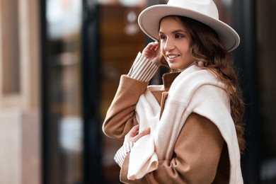 Photo of Charming young woman near shop on city street, space for text