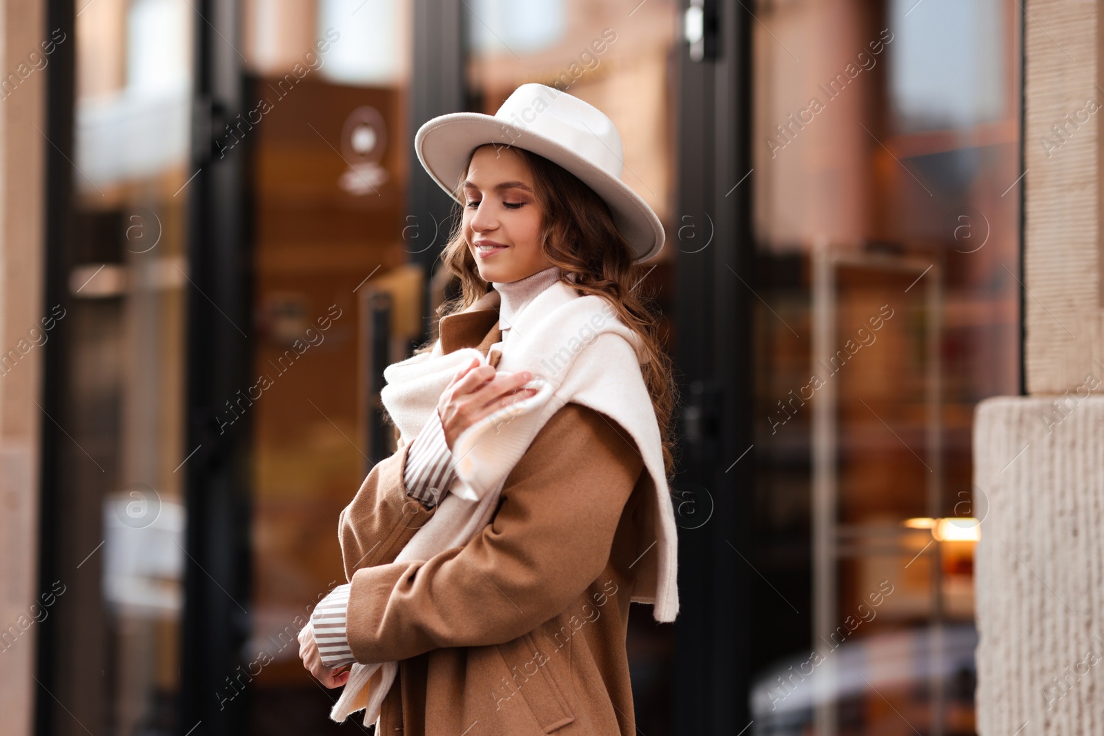 Photo of Charming young woman near shop on city street