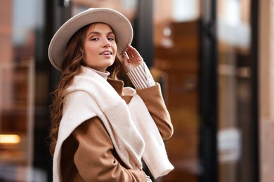 Photo of Charming young woman near shop on city street