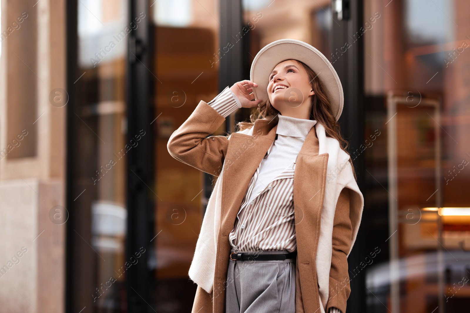 Photo of Charming young woman near shop on city street