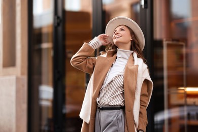 Photo of Charming young woman near shop on city street