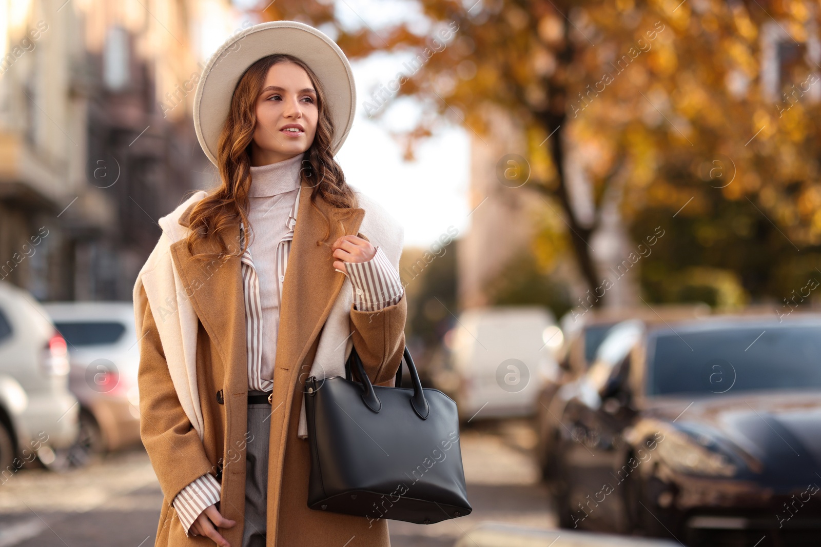 Photo of Young woman in beautiful outfit on city street, space for text. Autumn style