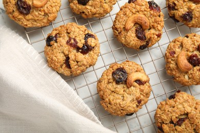 Photo of Delicious oatmeal cookies with raisins and nuts on white marble table, top view