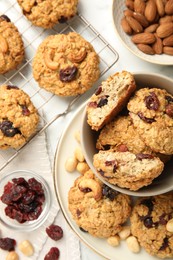 Photo of Delicious oatmeal cookies with raisins and nuts on white marble table, flat lay