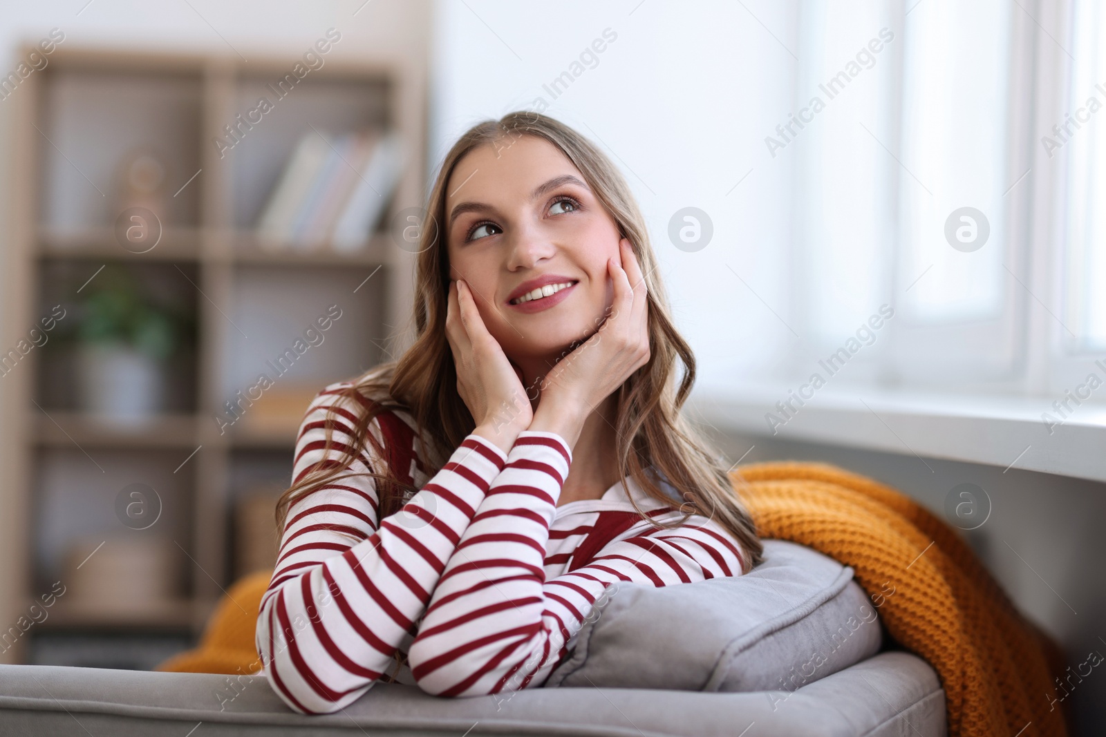 Photo of Charming young woman on sofa at home. Autumn atmosphere