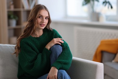 Photo of Charming young woman on sofa at home. Autumn atmosphere