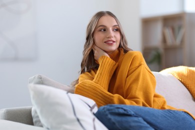 Photo of Charming young woman on sofa at home. Autumn atmosphere