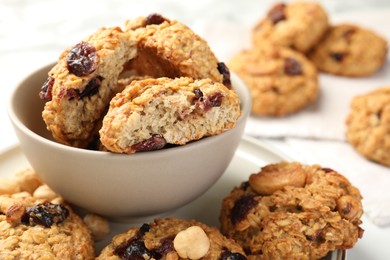 Photo of Delicious oatmeal cookies with raisins and nuts on table, closeup