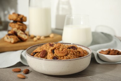 Delicious oatmeal cookies with raisins, nuts and milk on wooden table, closeup