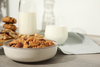 Delicious oatmeal cookies with raisins, nuts and milk on wooden table, closeup