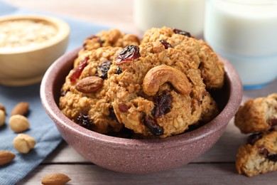 Delicious oatmeal cookies with raisins and nuts on wooden table, closeup