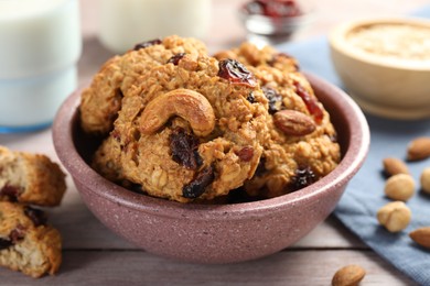 Photo of Delicious oatmeal cookies with raisins and nuts on wooden table, closeup