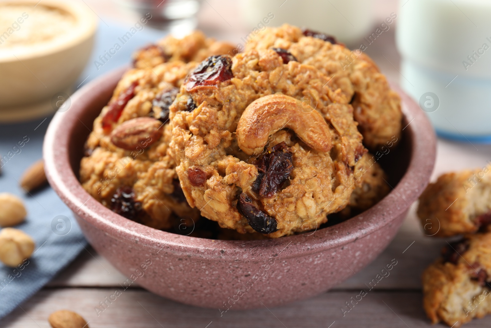 Photo of Delicious oatmeal cookies with raisins and nuts on wooden table, closeup