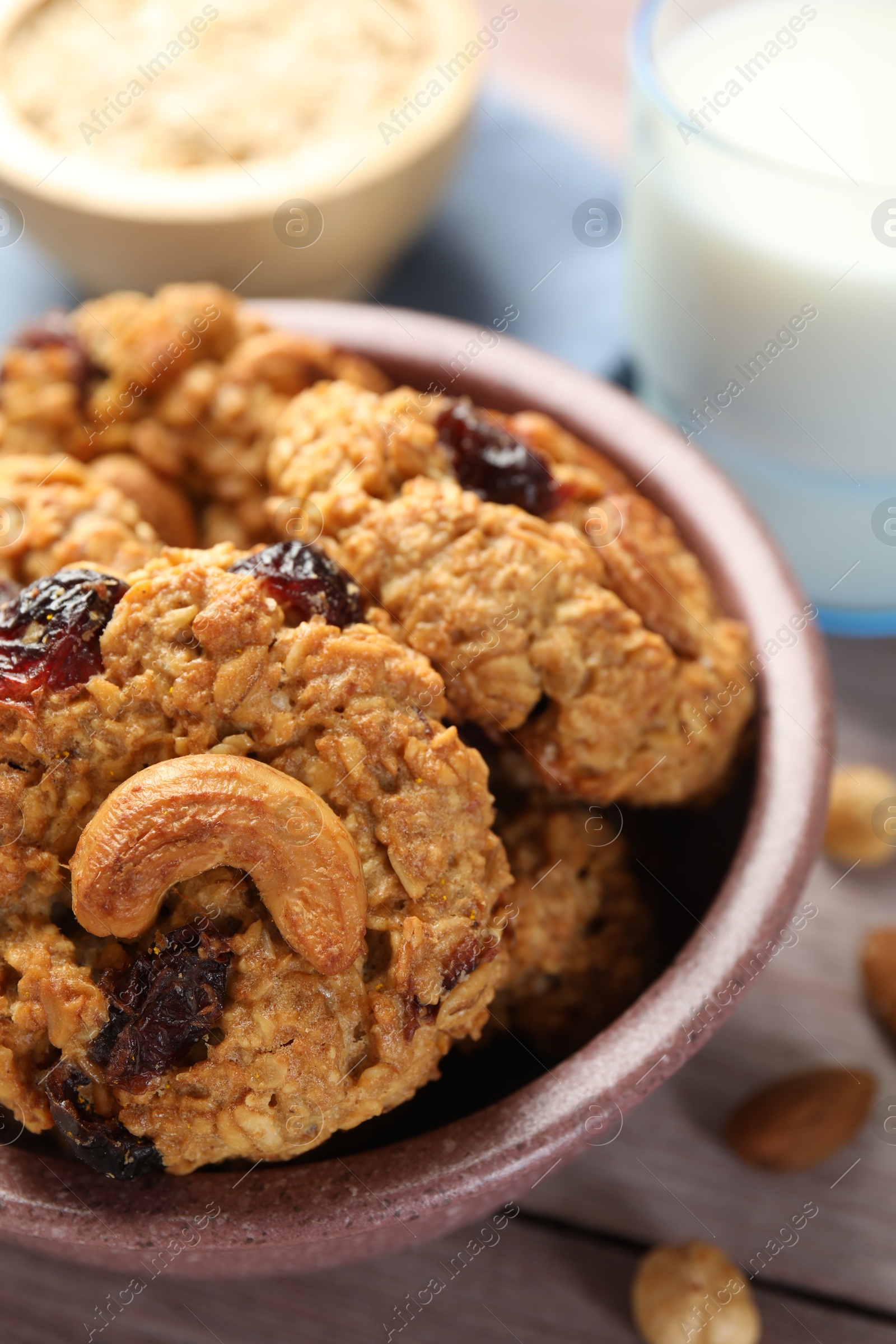 Photo of Delicious oatmeal cookies with raisins and nuts on wooden table, closeup