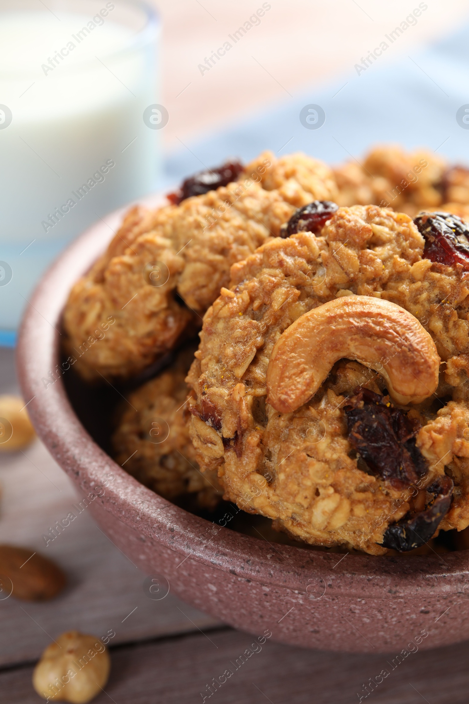 Photo of Delicious oatmeal cookies with raisins and nuts on wooden table, closeup