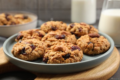 Delicious oatmeal cookies with raisins and nuts on table, closeup