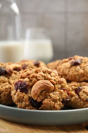 Delicious oatmeal cookies with raisins and nuts on table, closeup