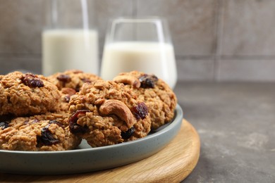 Delicious oatmeal cookies with raisins and nuts on grey table, closeup. Space for text