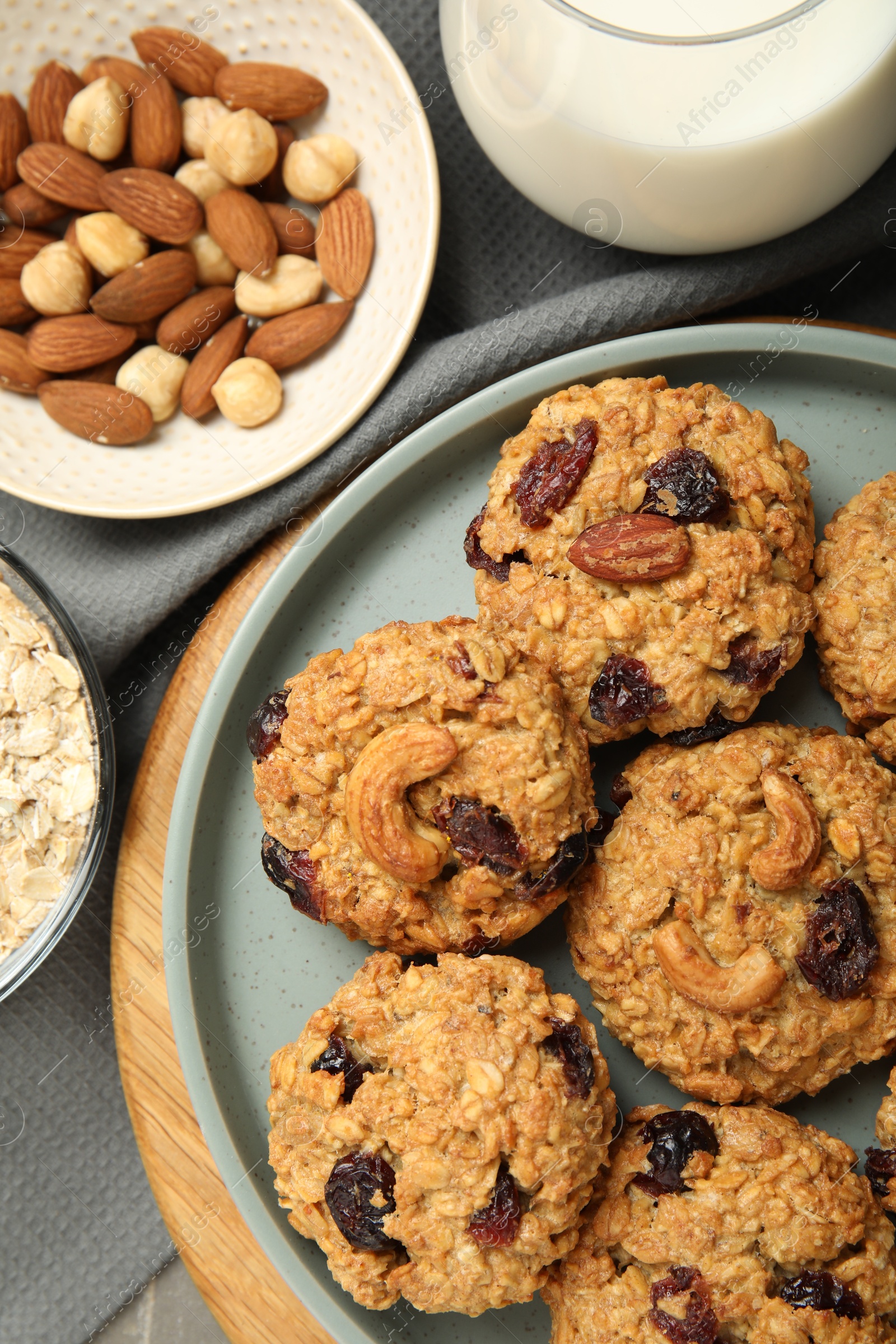 Photo of Delicious oatmeal cookies with raisins and nuts on table, top view