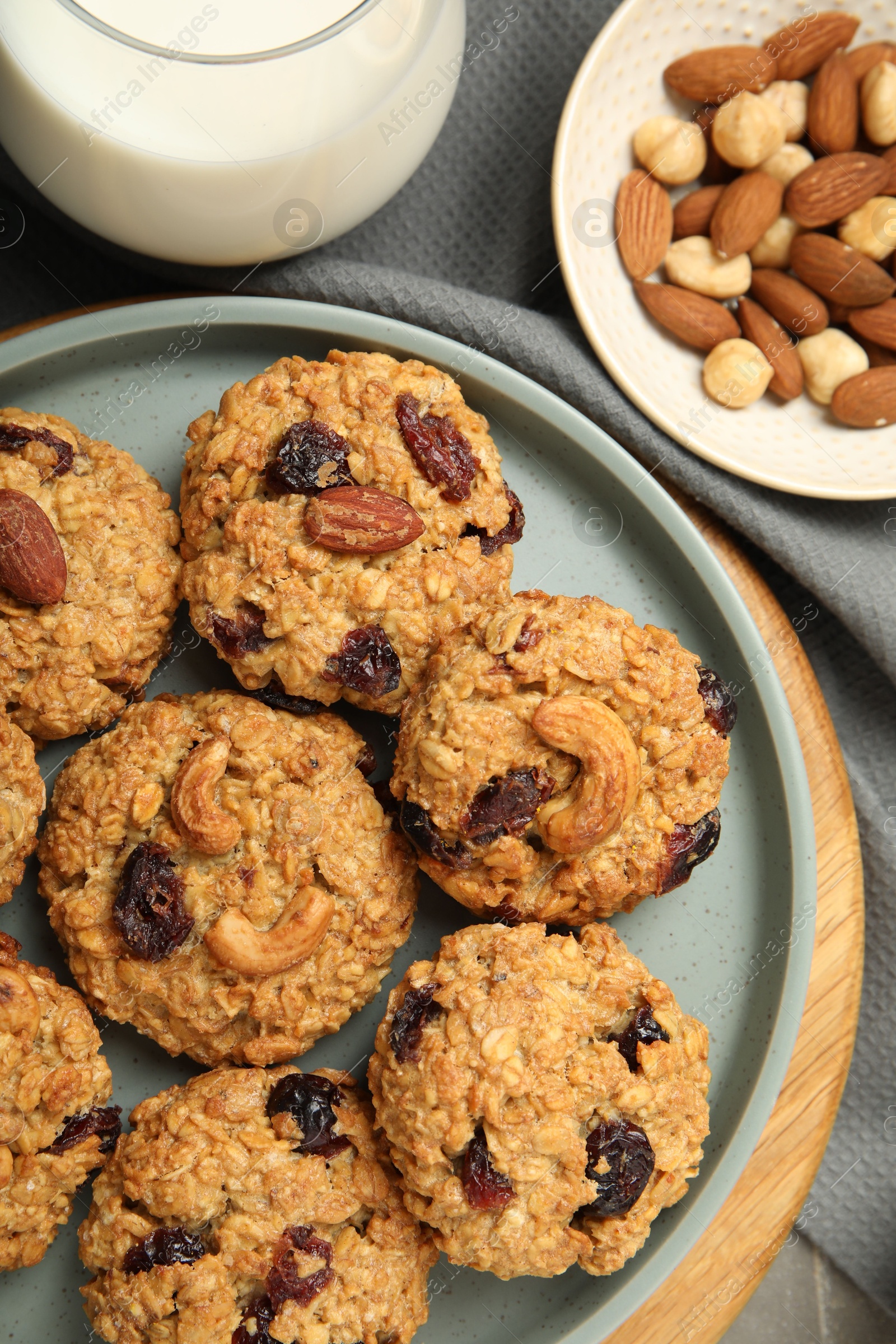 Photo of Delicious oatmeal cookies with raisins and nuts on table, top view