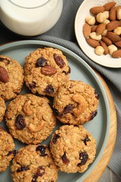 Delicious oatmeal cookies with raisins and nuts on table, top view