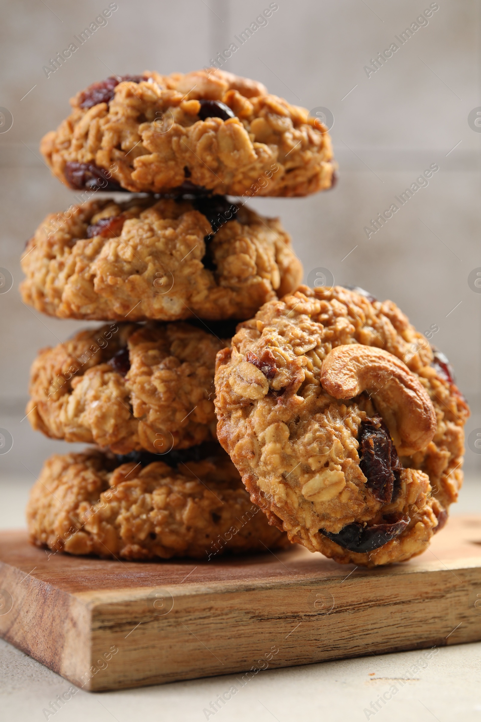 Photo of Delicious oatmeal cookies with raisins and nuts on light grey table, closeup