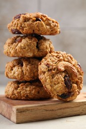 Delicious oatmeal cookies with raisins and nuts on light grey table, closeup