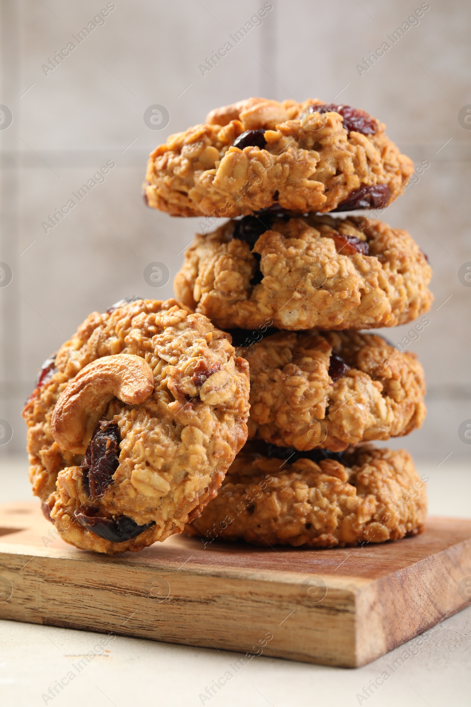 Photo of Delicious oatmeal cookies with raisins and nuts on light grey table, closeup