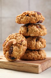 Photo of Delicious oatmeal cookies with raisins and nuts on light grey table, closeup