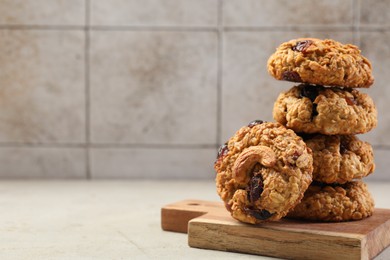 Photo of Delicious oatmeal cookies with raisins and nuts on light grey table, space for text