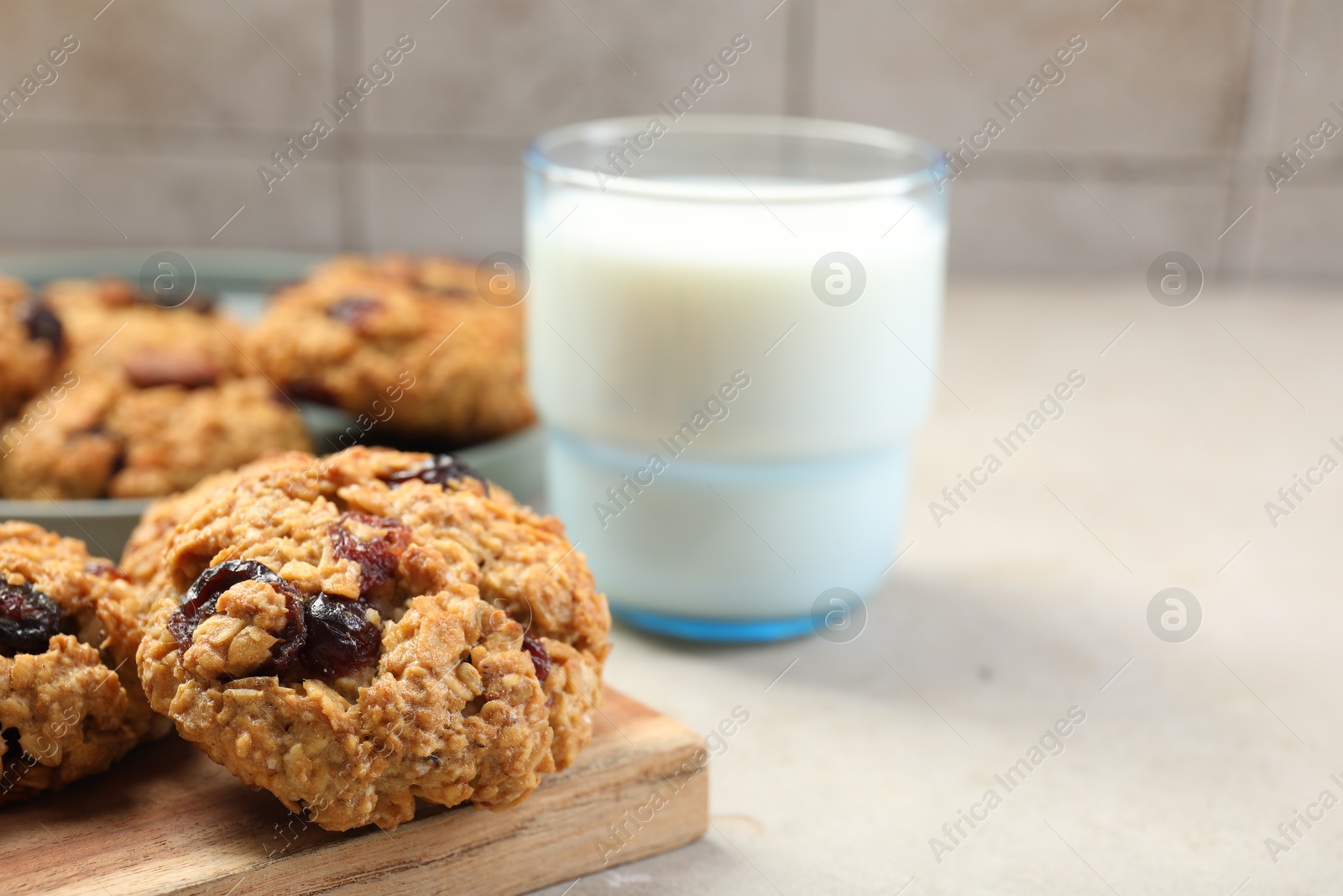 Photo of Delicious oatmeal cookies with raisins, nuts and milk on light grey table, closeup