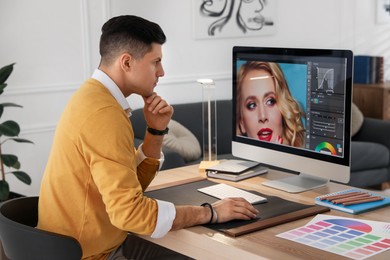 Photo of Professional retoucher working on computer in office