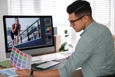 Professional retoucher working on computer in office